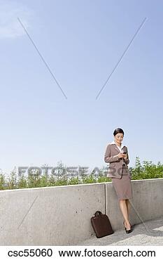 Stock Photography - businesswoman 
looking at cell 
phone. fotosearch 
- search stock 
photos, pictures, 
images, and photo 
clipart