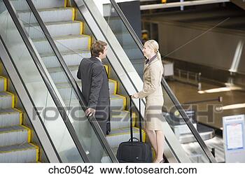 Stock Photo - businesspeople 
standing on escalator. 
fotosearch - search 
stock photos, 
pictures, images, 
and photo clipart