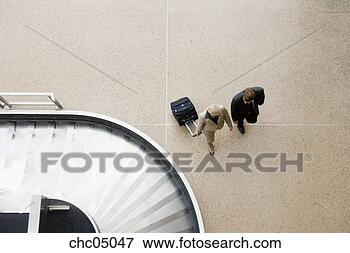 Picture - businesspeople 
walking past airport 
baggage claim. 
fotosearch - search 
stock photos, 
pictures, images, 
and photo clipart