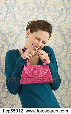 Stock Photo - grinning woman 
holding purse. 
fotosearch - search 
stock photos, 
pictures, images, 
and photo clipart