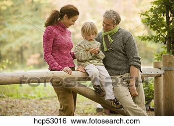 Stock Photo - family sitting 
on wooden gate. 
fotosearch - search 
stock photos, 
pictures, images, 
and photo clipart