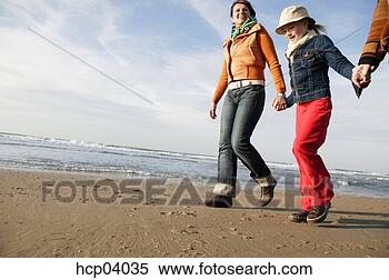 Stock Image - family walking 
on beach. fotosearch 
- search stock 
photos, pictures, 
images, and photo 
clipart