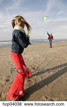 Stock Photo - father and daughter 
flying kite on 
beach. fotosearch 
- search stock 
photos, pictures, 
images, and photo 
clipart