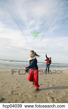 Stock Photograph - father and daughter 
flying kite on 
beach. fotosearch 
- search stock 
photos, pictures, 
images, and photo 
clipart
