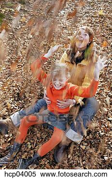Stock Image - mother and daughter 
throwing leaves. 
fotosearch - search 
stock photos, 
pictures, images, 
and photo clipart