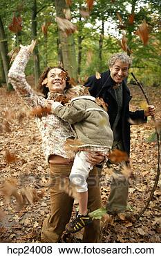 Stock Photo - mother, father 
and daughter throwing 
autumn leaves 
in the woods. 
fotosearch - search 
stock photos, 
pictures, images, 
and photo clipart