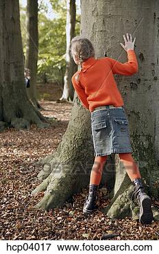 Picture - young girl playing 
hide and seek 
in forest. fotosearch 
- search stock 
photos, pictures, 
images, and photo 
clipart