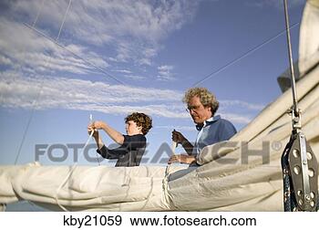 Stock Photograph - father and son 
untying sail. 
fotosearch - search 
stock photos, 
pictures, images, 
and photo clipart