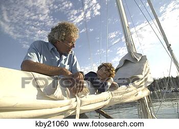 Stock Photography - father and son 
untying sail. 
fotosearch - search 
stock photos, 
pictures, images, 
and photo clipart