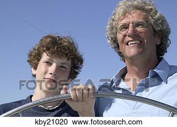 Stock Photography - father teaching 
son to steer boat. 
fotosearch - search 
stock photos, 
pictures, images, 
and photo clipart