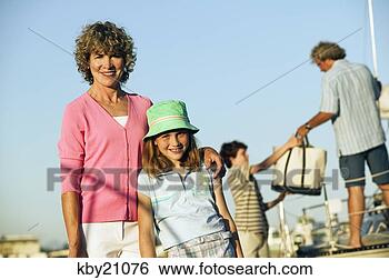 Stock Photo - mother and daughter 
smiling while 
father and son 
load up boat. 
fotosearch - search 
stock photos, 
pictures, images, 
and photo clipart