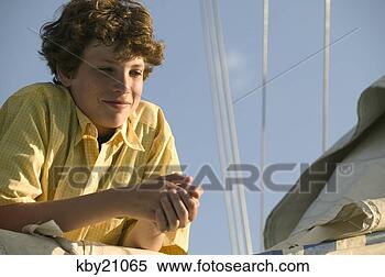 Stock Image - teenage boy leaning 
on sail. fotosearch 
- search stock 
photos, pictures, 
images, and photo 
clipart