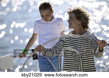 Stock Photograph - woman steering 
boat. fotosearch 
- search stock 
photos, pictures, 
images, and photo 
clipart