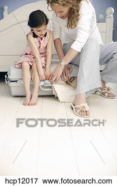 Foto - mãe,  filha,  
embalagem,  mala. 
fotosearch - busca 
de fotos, imagens 
e clipart
