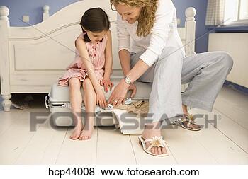 Stock Photo - mother and daughter 
packing suitcase. 
fotosearch - search 
stock photos, 
pictures, images, 
and photo clipart