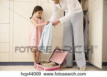 Stock Photograph - mother and daughter 
packing suitcase. 
fotosearch - search 
stock photos, 
pictures, images, 
and photo clipart