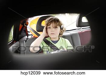 Stock Photograph - young boy listening 
to headphones 
in backseat. fotosearch 
- search stock 
photos, pictures, 
images, and photo 
clipart
