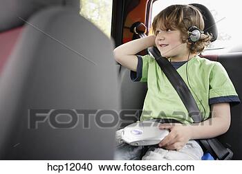Stock Photography - young boy listening 
to headphones 
in backseat. fotosearch 
- search stock 
photos, pictures, 
images, and photo 
clipart