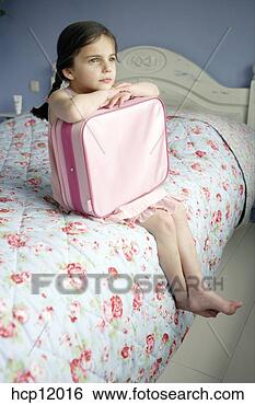 Stock Photo - young girl holding 
suitcase on bed. 
fotosearch - search 
stock photos, 
pictures, images, 
and photo clipart
