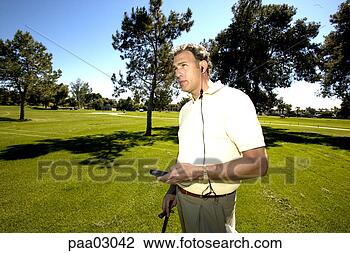 Stock Photo - man listening 
to hands free-device 
on golf course. 
fotosearch - search 
stock photos, 
pictures, images, 
and photo clipart
