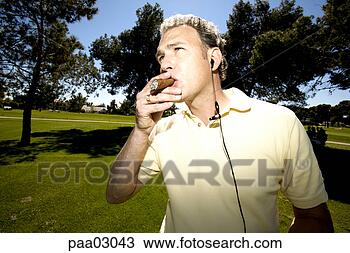 Stock Photo - man smoking cigar 
on golf course. 
fotosearch - search 
stock photos, 
pictures, images, 
and photo clipart