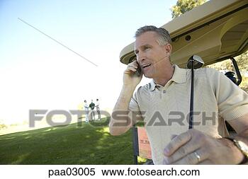 Stock Image - man talking on 
cell phone at 
golf course. fotosearch 
- search stock 
photos, pictures, 
images, and photo 
clipart