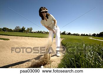 Stock Photography - woman hitting 
golf ball out 
of bunker. fotosearch 
- search stock 
photos, pictures, 
images, and photo 
clipart