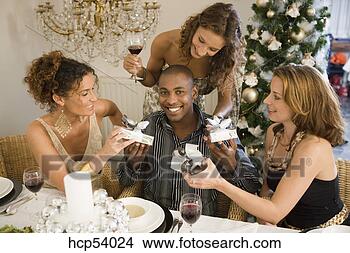 Stock Photo - people exchanging 
gifts at dinner 
party. fotosearch 
- search stock 
photos, pictures, 
images, and photo 
clipart