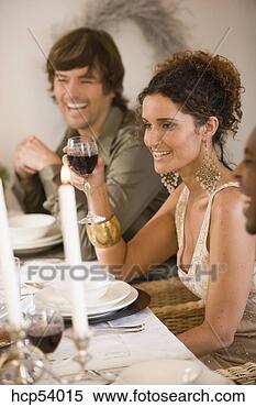 Stock Image - woman drinking 
wine at dinner 
table with friends. 
fotosearch - search 
stock photos, 
pictures, images, 
and photo clipart