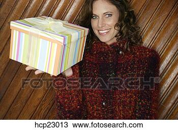 Stock Photo - smiling woman 
holding gift. 
fotosearch - search 
stock photos, 
pictures, images, 
and photo clipart