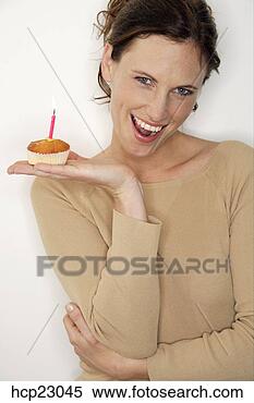 Stock Image - woman holding 
birthday cupcake 
with candle. fotosearch 
- search stock 
photos, pictures, 
images, and photo 
clipart