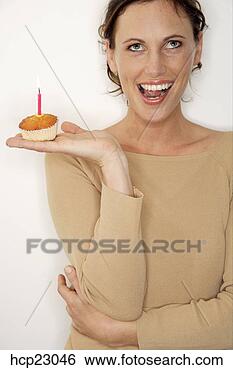 Stock Photo - woman holding 
birthday cupcake 
with candle. fotosearch 
- search stock 
photos, pictures, 
images, and photo 
clipart