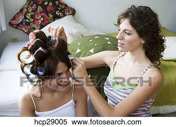 Stock Image - young women styling 
hair in rollers. 
fotosearch - search 
stock photos, 
pictures, images, 
and photo clipart