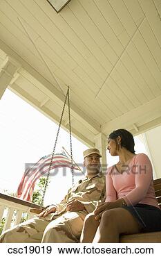 Arquivo Fotográficos - hispânico,  militar, 
 solda,  esposa, 
 sentando,  alpendre, 
 balanço. fotosearch 
- busca de fotos, 
imagens e clipart
