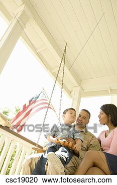 Arquivo de Fotografias - hispânico,  militar, 
 solda,  família, 
 sentando,  alpendre, 
 balanço. fotosearch 
- busca de fotos, 
imagens e clipart
