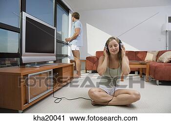 Arquivo de Fotografia - mulher,  escutar, 
 fones. fotosearch 
- busca de fotos, 
imagens e clipart