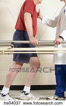 Picture - man using bars 
to walk with physical 
therapist. fotosearch 
- search stock 
photos, pictures, 
images, and photo 
clipart