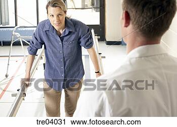 Stock Photography - woman using bars 
to walk talking 
to physical therapist. 
fotosearch - search 
stock photos, 
pictures, images, 
and photo clipart