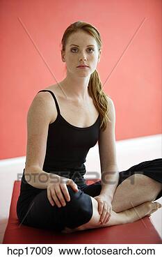 Stock Photograph - young woman sitting 
cross-legged on 
mat. fotosearch 
- search stock 
photos, pictures, 
images, and photo 
clipart