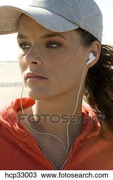 Banco de Imagem - jovem,  mulher, 
 escutar,  earbuds, 
 desgastar,  basebol, 
 boné. fotosearch 
- busca de fotos, 
imagens e clipart