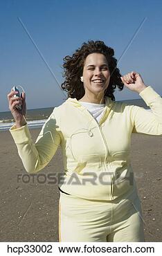 Banco de Imagem - mulher,  escutar, 
 música,  sacudindo, 
 praia. fotosearch 
- busca de fotos, 
imagens e clipart