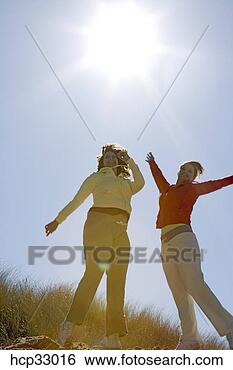Banco de Imagem - mulheres,  pular, 
 alegria,  praia. 
fotosearch - busca 
de fotos, imagens 
e clipart