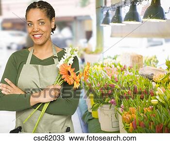 Stock Photo - african female 
florist holding 
flowers. fotosearch 
- search stock 
photos, pictures, 
images, and photo 
clipart