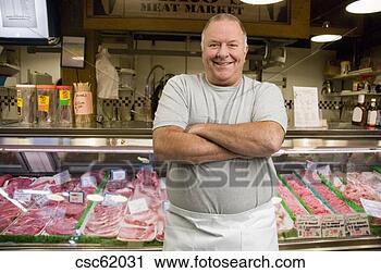 Stock Photography - male butcher in 
front of meat 
counter. fotosearch 
- search stock 
photos, pictures, 
images, and photo 
clipart