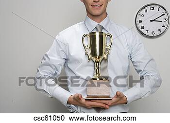 Stock Photography - businessman holding 
trophy. fotosearch 
- search stock 
photos, pictures, 
images, and photo 
clipart