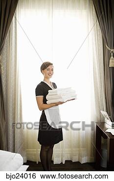 Stock Photo - maid holding stack 
of towels. fotosearch 
- search stock 
photos, pictures, 
images, and photo 
clipart