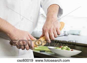 Arquivo Fotográficos - macho,  cozinheiro, 
 quebrar,  pão, 
 metade. fotosearch 
- busca de fotos, 
imagens e clipart