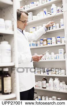 Stock Photography - pharmacist looking 
at prescription 
and reaching for 
pill bottle. fotosearch 
- search stock 
photos, pictures, 
images, and photo 
clipart
