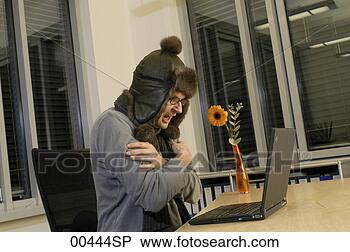 Stock Photo - man working at 
laptop, wearing 
cap, arms crossed. 
fotosearch - search 
stock photos, 
pictures, images, 
and photo clipart
