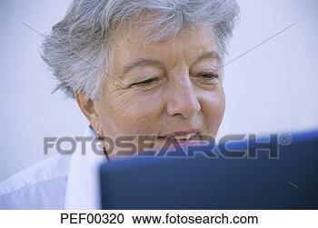 Stock Photography - senior woman using 
laptop, smiling. 
fotosearch - search 
stock photos, 
pictures, images, 
and photo clipart